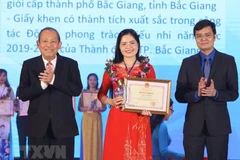 Phó Thủ tướng Thường trực Trương Hòa Bình (bên trái) và Bí thư Trung ương Đoàn, Chủ tịch Trung ương Hội Sinh viên Việt Nam Bùi Quang Huy trao Bằng khen và biểu trưng, tuyên dương 'Nhà giáo trẻ tiêu biểu' cấp Trung ương lần thứ II.(Ảnh: Văn Điệp/TTXVN)