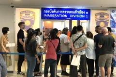 Nhiều người nước ngoài xếp hàng bên ngoài văn phòng Cục Di trú Thái Lan ở Bangkok để xin gia hạn thị thực nhập cảnh ngày 23/3. (Ảnh: Ngọc Quang/TTXVN)