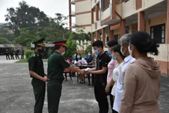 Cán bộ chiến sỹ trao Giấy chứng nhận hoàn thành thời gian cách ly cho người dân. (Ảnh: Mai Trang/TTXVN)