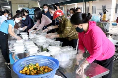 Chị em phụ nữ xã Thịnh Lộc, huyện Lộc Hà (Hà Tĩnh) chuẩn bị cơm, nước phục vụ người được cách ly. Ảnh: Công Tường/TTXVN)