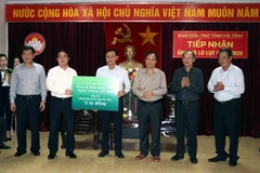 Doanh nghiệp khối cơ quan Trung ương Ngân hàng TMCP Ngoại thương Việt Nam trao tiền ủng hộ cho Hà Tĩnh. (Ảnh: Công Tường/TTXVN)