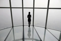 Một người phụ nữ nhìn qua ô cửa ở Seoul bị che phủ bởi bụi mịn. (Ảnh: Reuters)