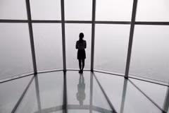 Một người phụ nữ nhìn qua ô cửa ở Seoul bị che phủ bởi bụi mịn. (Ảnh: Reuters)