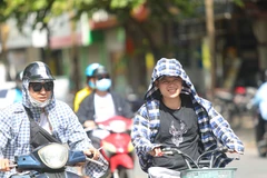 Thời tiết nắng nóng, tia UV ở mức cao, người dân cần trang bị tốt đồ bảo hộ khi ra đường để bảo vệ sức khỏe. (Ảnh: Thanh Tùng/TTXVN)