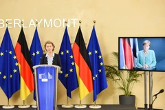Chủ tịch Ủy ban châu Âu (EC) Ursula von der Leyen (trái) ở Brussels (Bỉ) trong cuộc thảo luận trực tuyến với Thủ tướng Đức Angela Merkel (trên màn hình). (Ảnh: THX/TTXVN)