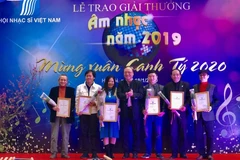 Lãnh đạo Hội Nhạc sỹ Việt Nam trao giải thưởng cho các tác giả. (Ảnh: Phương Lan/TTXVN)