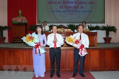 Ông Trần Văn Huyến, Phó Bí thư Thường trực Tỉnh ủy, Chủ tịch Hội đồng Nhân dân tỉnh Hậu Giang tặng hoa chúc mừng hai Phó Chủ tịch UBND tỉnh Hậu Giang, bà Hồ Thu Ánh (trái) và ông Nguyễn Văn Hòa (phải). (Ảnh: Hồng Thái/TTXVN)