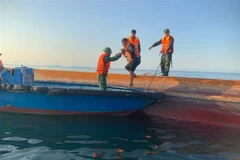 Cán bộ, chiến sỹ Đồn Biên phòng Cát Bà đang ứng cứu thuyền viên bị bạn trên biển. (Ảnh: TTXVN)