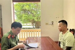 Lực lượng công an lấy lời khai của đối tượng Vũ Văn Quỳnh. (Ảnh: Trịnh Duy Hưng/TTXVN)