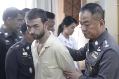 Cảnh sát áp giải nghi can Adem Karadag tới trụ sở Cục cảnh sát thành phố tại Bangkok. (Nguồn: THX/TTXVN)