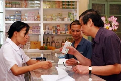 Kiểm tra chất lượng và giá cả thuốc chữa bệnh tại một cửa hàng bán thuốc ở huyện Đông Anh. (Ảnh: Hữu Oai/TTXVN)