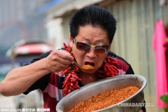 Ông Lý Vĩnh Chí biểu diễn khả năng ăn ớt đặc biệt của mình. (Nguồn: Chinadaily)