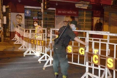 Lực lượng chức năng lập hàng rào phong tỏa và chốt chặn khu vực bị cách ly. (Ảnh: Quốc Dũng/TTXVN)