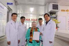Lãnh đạo bệnh viện Chợ Rẫy trao giấy xác nhận xét nghiệm COVID-19 với kết quả 9 lần âm tính liên tiếp. (Ảnh: TTXVN phát)