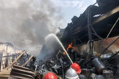 Lực lượng chức năng tiếp cận hiện trường, tích cực chữa cháy. (Ảnh: Nhật Anh/TTXVN)