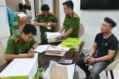 Hiện trường khám xét nhà đối tượng Trần Viết Nghĩa (áo đen, bên phải). (Ảnh: TTXVN phát)