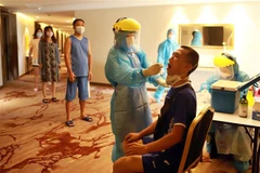 Lấy dịch xét nghiệm tìm virus SARS-CoV-2 ở tại Khách sạn DIC STAR thành phố Vĩnh Yên, Vĩnh Phúc. (Ảnh: Hoàng Hùng/TTXVN)