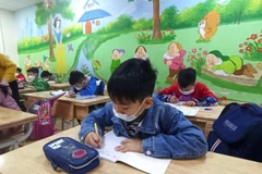 Phụ huynh mong mỏi con được đến trường. (Ảnh: Phạm Mai/Vietnam+)