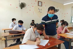 Thí sinh làm thủ tục dự thi Tốt nghiệp Trung học phổ thông. (Ảnh: Phạm Mai/Vietnam+)
