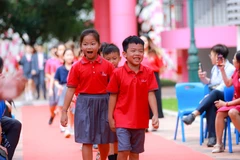 Học sinh mới bước vào trong tiếng vỗ tay chào đón nồng nhiệt. (Ảnh: Minh Sơn/Vietnam+)