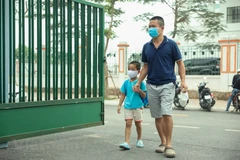 Phụ huynh học sinh Trường Mầm non Hoàng Liệt (quận Hoàng Mai) đưa con đến trường. (Ảnh: Minh Hiếu/Vietnam+)