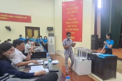 Phụ huynh bốc thăm suất học cho con. (Ảnh: PV/Vietnam+)