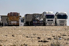 Xe tải chở hàng viện trợ cho Dải Gaza tập trung gần cửa khẩu Rafah bên phía Ai Cập, ngày 23/3. (Ảnh: AFP/TTXVN)