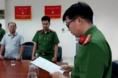 Cán bộ Cơ quan Cảnh sát Điều tra - Công an tỉnh Bà Rịa-Vũng Tàu đọc lệnh khởi tố bị can đối với ông Phạm Minh An. (Ảnh: Công an cung cấp)