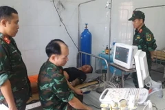 Quân y đảo Song Tử Tây điều trị cho một ngư dân. (Ảnh: TTXVN phát)