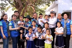Chuẩn Đô đốc Phạm Như Xuân, Phó Tư lệnh Hải quân cùng Phó Bí thư Thành ủy Thành phố Hồ Chí Minh Nguyễn Phước Lộc và thiếu nhi trên đảo Trường Sa lớn. (Ảnh: Xuân Khu/TTXVN)