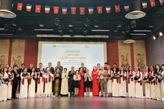 Đại sứ Đinh Toàn Thắng và Giám đốc Khu di tích Lê Thị Phượng cùng dàn Hợp ca quê hương hát bài hát ca ngợi Chủ tịch Hồ Chí Minh. (Ảnh: Ngọc Hiệp/TTXVN)