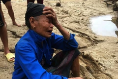 Người dân ra bờ suối mong người thân trở về sau trận lũ dữ. (Ảnh: Trịnh Duy Hưng/TTXVN) 