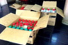 Hàng chục chai dầu nhớt nghi giả thương hiệu bị Quản lý thị trường thu giữ. (Ảnh: Thành Chung/ TTXVN) 