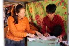 Cô giáo Nguyễn Thùy Dung, trường Trung học cơ sở Mường Khiêng, giúp học sinh được đỡ đầu làm bài tập. (Ảnh: Hữu Quyết/TTXVN)