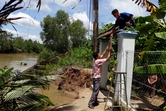 Sạt lở làm mất đường đi và ăn sâu vào sát cổng nhà dân. (Ảnh: Thanh Liêm/TTXVN)