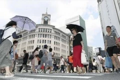 Người dân che ô tránh nắng tại Ginza, thủ đô Tokyo, Nhật Bản ngày 14/7. (Ảnh: Kyodo/TTXVN)