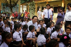 Bộ trưởng Phùng Xuân Nhạ với học sinh Trường tiểu học Tân Hóa, huyện Minh Hóa, tỉnh Quảng Bình. (Ảnh: Văn Tý/TTXVN)