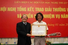 Tác giả Lò Văn Hợp với tác phẩm ảnh 'Chung sức' nhận giải A, giải thưởng Văn học Nghệ thuật Việt Nam 2018 ở hạng mục dành cho các tác giả là hội viên các hội văn học nghệ thuật địa phương. (Ảnh: Thanh Tùng/TTXVN)