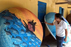 Những tác phẩm hội họa nhiều màu sắc, độc đáo được các họa sỹ thể hiện trên những chiếc thuyền thúng. (Ảnh: Đỗ Trưởng/TTXVN)