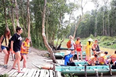 Du khách quốc tế tham quan khu du lịch Gáo Giồng, huyện Cao Lãnh vào mùa nước nổi. (Ảnh: Đình Huệ/TTXVN)