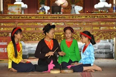 Chị Phạm Thị Kim Ngân, chủ nhiệm CLB hát xẩm của xã Yên Nhân (huyện Yên Mô, Ninh Bình) hướng dẫn hát xẩm cho các thế hệ sau. (Ảnh: Minh Đức/TTXVN)