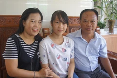 Em Hà Phương và bố mẹ trong niềm vui đón nhận danh hiệu thủ khoa toàn quốc. (Nguồn: TTXVN)