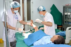 Các y bác sỹ Bệnh viện Đa khoa Hùng Vương điều trị vết thương cho bệnh nhi bị bỏng. (Ảnh: Trung Kiên/TTXVN)