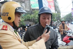 Cảnh sát giao thông kiểm tra nồng độ cồn với lái xe. (Nguồn: TTXVN)