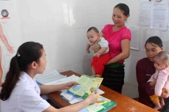 Y, bác sỹ Trạm Y tế xã Hạnh Dịch, huyện Quế Phong (Nghệ An) tư vấn, khám bệnh cho đồng bào dân tộc thiểu số. (Ảnh: Thanh Tùng/TTXVN)