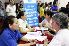 Tư vấn bảo hiểm y tế, bảo hiểm xã hội. (Ảnh: Thanh Vũ/TTXVN) 