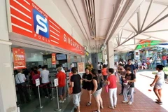 Người dân Singapore xếp hàng đợi cá cược tại một đại lý của Singapore Pools. (Nguồn: straitstimes.com)