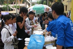 Tình nguyện viên Đại học Luật đang đưa cơm cho thí sinh. (Ảnh: Hồng Kiều/Vietnam+)