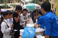 Tình nguyện viên Đại học Luật đang đưa cơm cho thí sinh. (Ảnh: Hồng Kiều/Vietnam+)