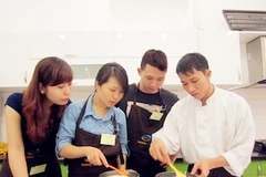 Những bạn trẻ đang chăm chú học cách pha bột. (Ảnh: PV/Vietnam+)